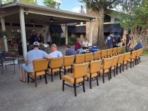 A group of people sitting in chairs outside.