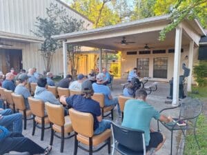 A group of people sitting in chairs outside