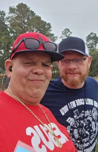 Two men standing next to each other in a park.