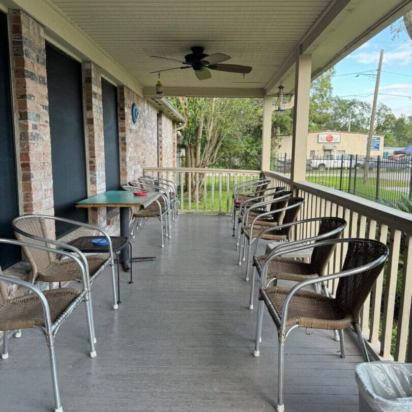 A porch with chairs and tables on it